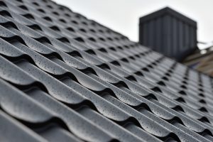 Metal roof with water drops after rain. Roof construction site. Metal roofing